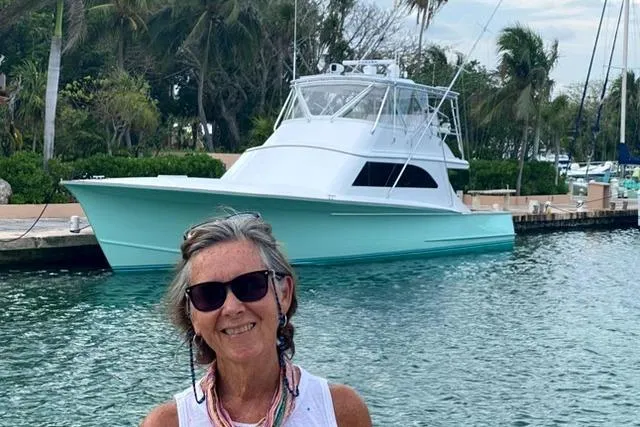 Sea Hag Yacht Photos Pics Woman smiling near 2008 Blackwell Custom Carolina 61 yacht docked by palm trees.
