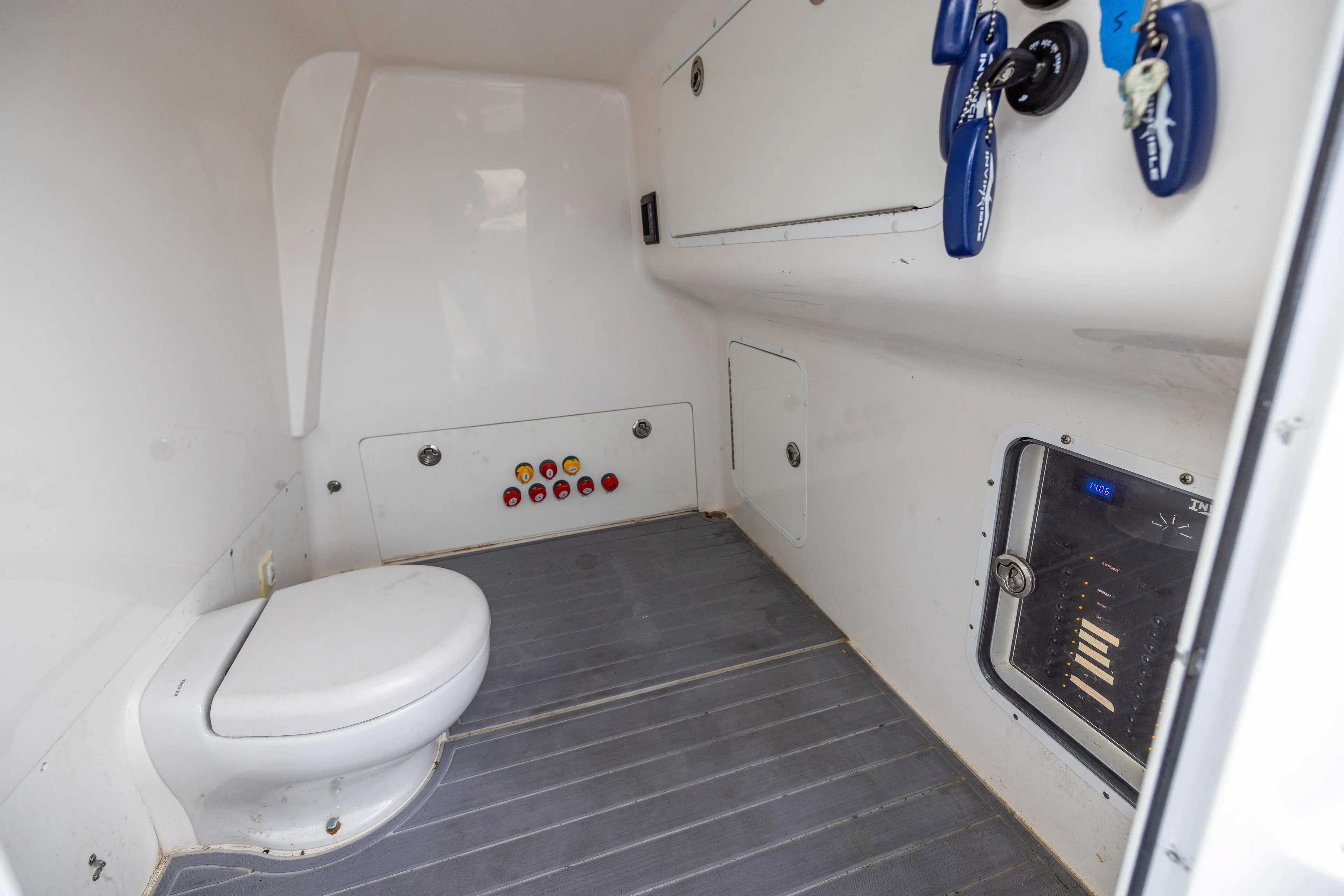  Yacht Photos Pics Interior of 2020 Invincible 40 Catamaran featuring a compact marine toilet and control panel.