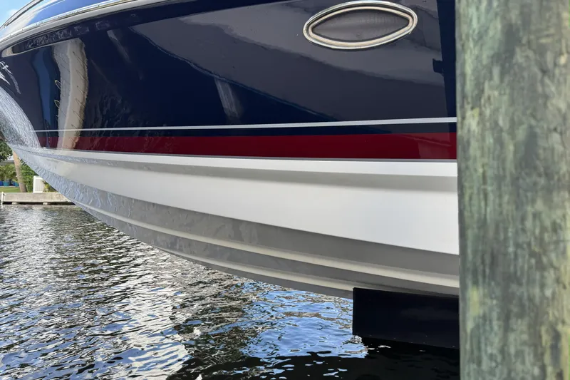  Yacht Photos Pics 2021 Formula 330 Crossover Bowrider OB boat hull near dock, reflecting on water.