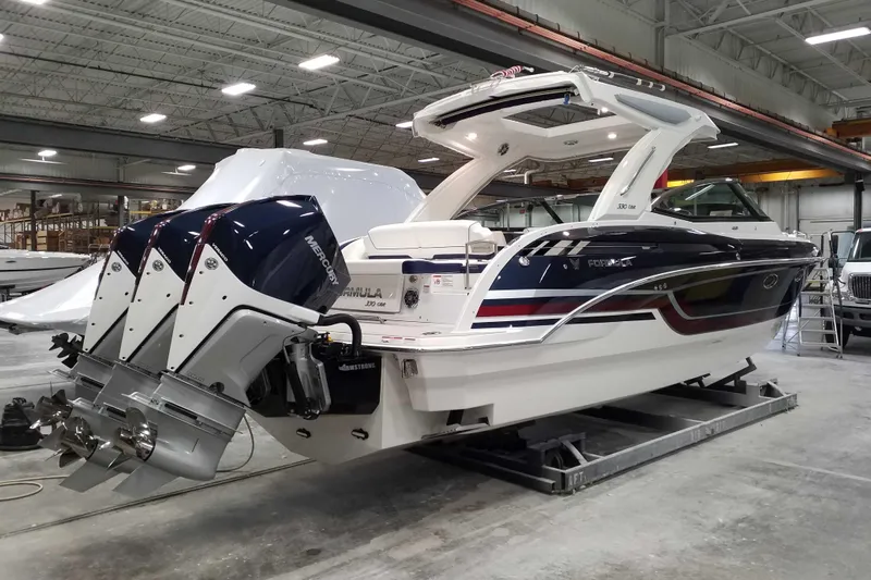  Yacht Photos Pics 2021 Formula 330 Crossover Bowrider OB in a warehouse, featuring dual outboard engines.