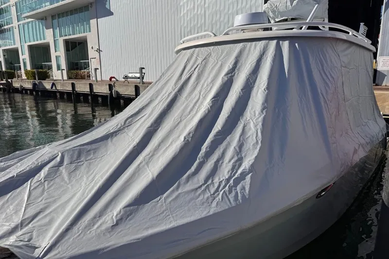  Yacht Photos Pics 2021 Robalo R317 Dual Console boat covered with tarp at marina dock.
