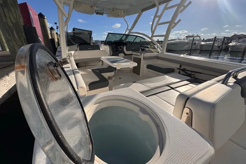  Yacht Photos Pics 2021 Robalo R317 Dual Console boat interior with seating and open hatch, docked at marina.
