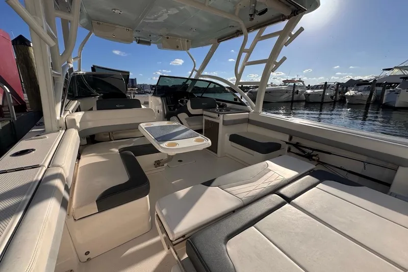  Yacht Photos Pics 2021 Robalo R317 Dual Console boat interior with seating and table, docked at marina.