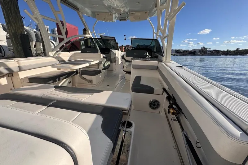 Yacht Photos Pics 2021 Robalo R317 Dual Console boat interior with seating and table, docked by the water.