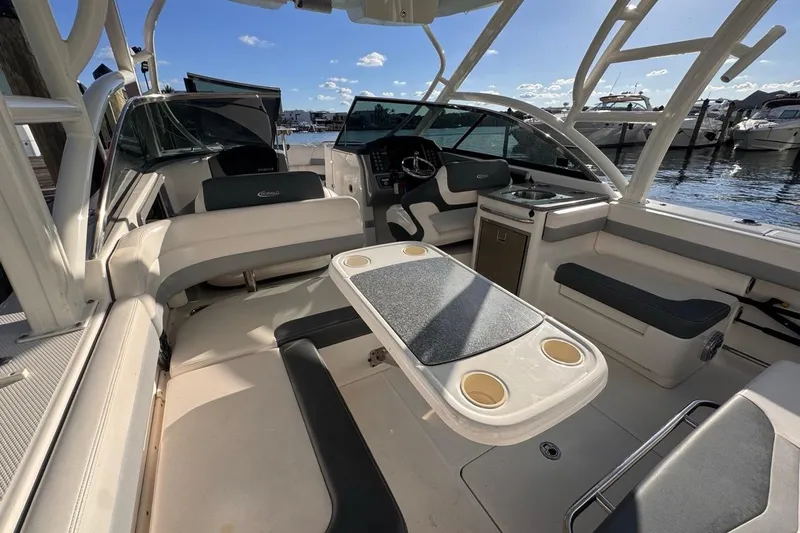 Yacht Photos Pics 2021 Robalo R317 Dual Console boat interior with seating and table, docked at marina.