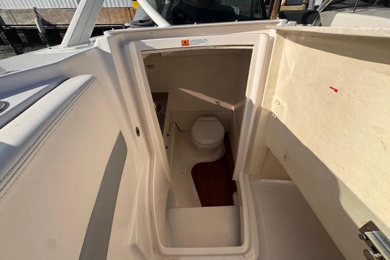  Yacht Photos Pics 2021 Robalo R317 Dual Console boat interior with compact marine toilet.