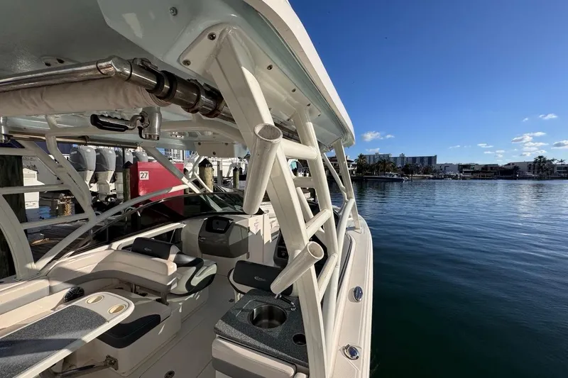  Yacht Photos Pics 2021 Robalo R317 Dual Console boat docked by calm waters under clear blue sky.