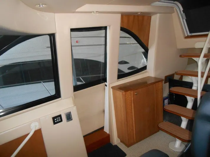  Yacht Photos Pics Interior of 2004 Meridian 540 Pilothouse with wooden cabinetry and spiral staircase.