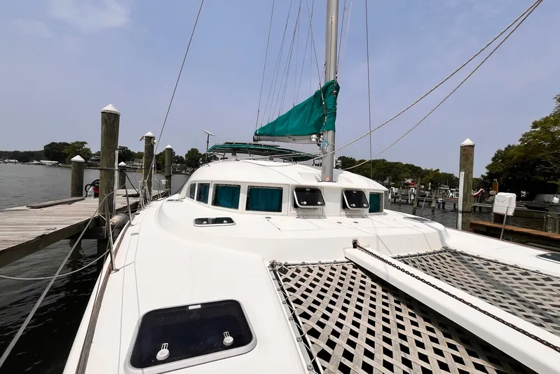 Wayward Sun Yacht Photos Pics Lagoon 380 catamaran, 2000 model, docked at a marina with green sail cover.