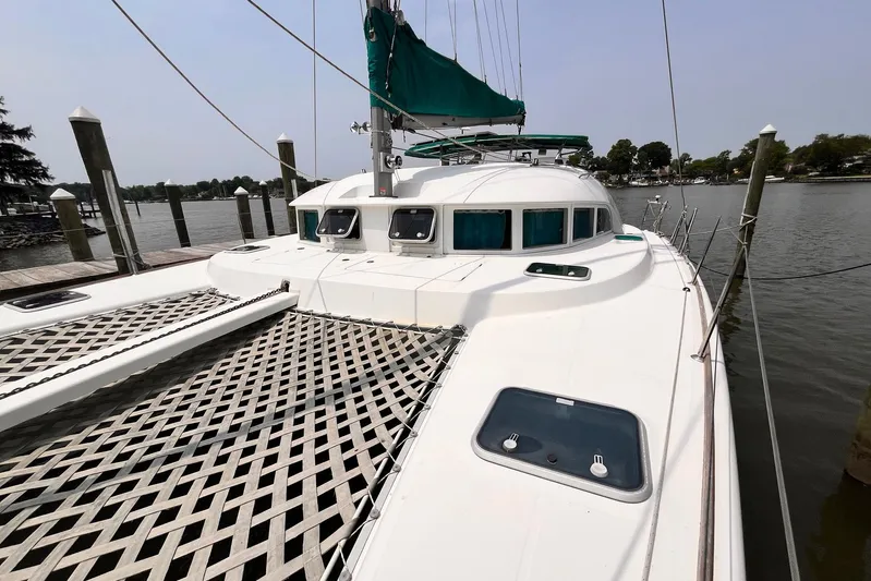 Wayward Sun Yacht Photos Pics 2000 Lagoon 380 catamaran docked, featuring spacious deck and green sail.