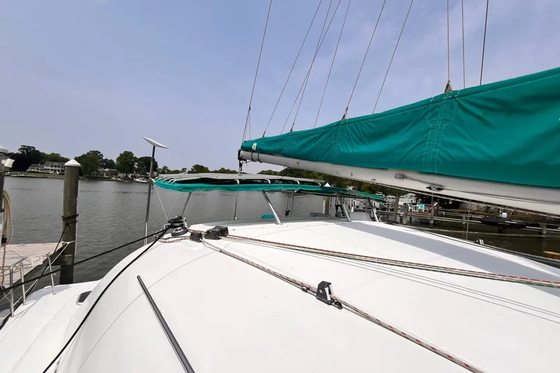 Wayward Sun Yacht Photos Pics Lagoon 380 catamaran from 2000 docked, featuring teal sail covers and calm waters.