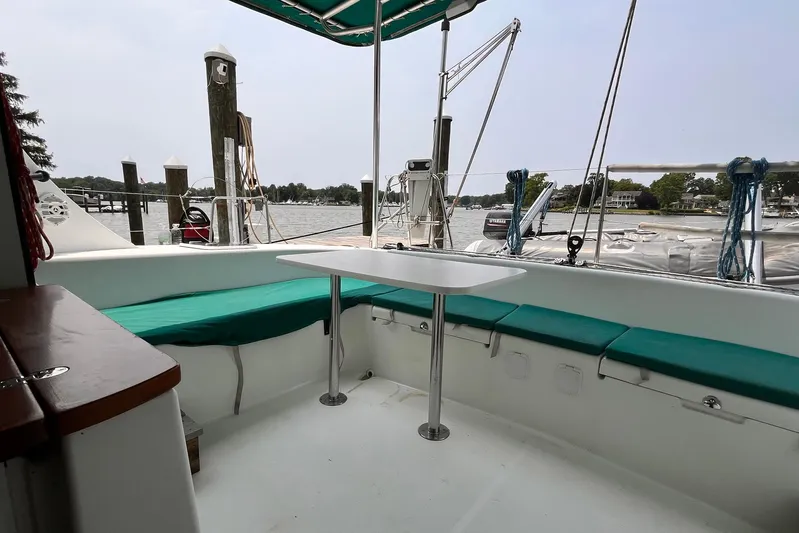 Wayward Sun Yacht Photos Pics Lagoon 380 catamaran cockpit with green seating, table, and marina view.