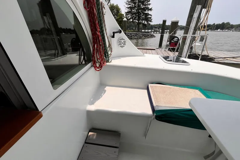 Wayward Sun Yacht Photos Pics Lagoon 380 catamaran deck area with seating, docked by a serene waterfront.