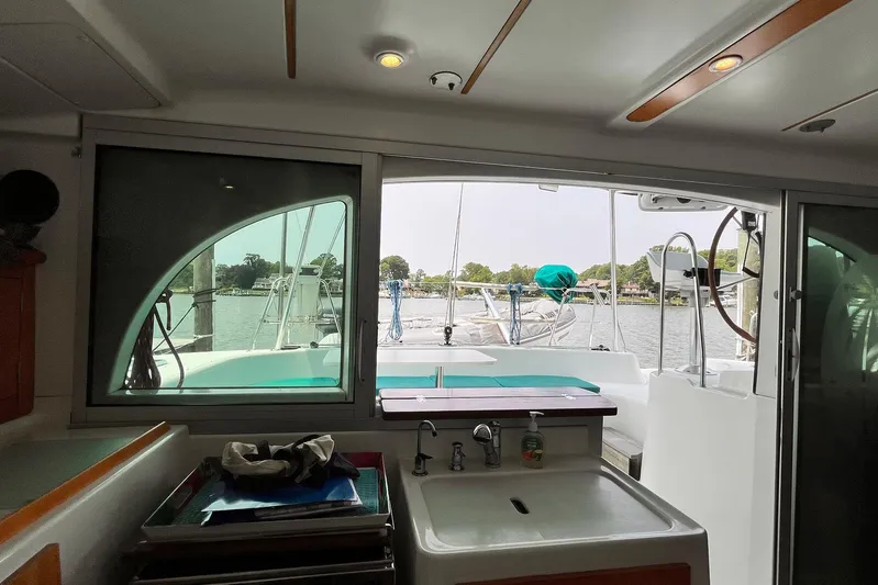 Wayward Sun Yacht Photos Pics Interior view of 2000 Lagoon 380 catamaran with outdoor deck and water scenery.