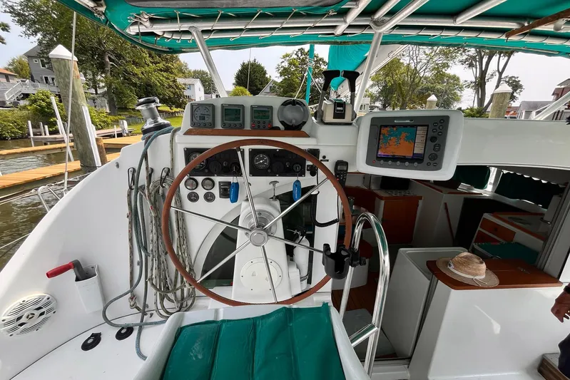 Wayward Sun Yacht Photos Pics Cockpit of 2000 Lagoon 380 catamaran with navigation equipment and wooden steering wheel.