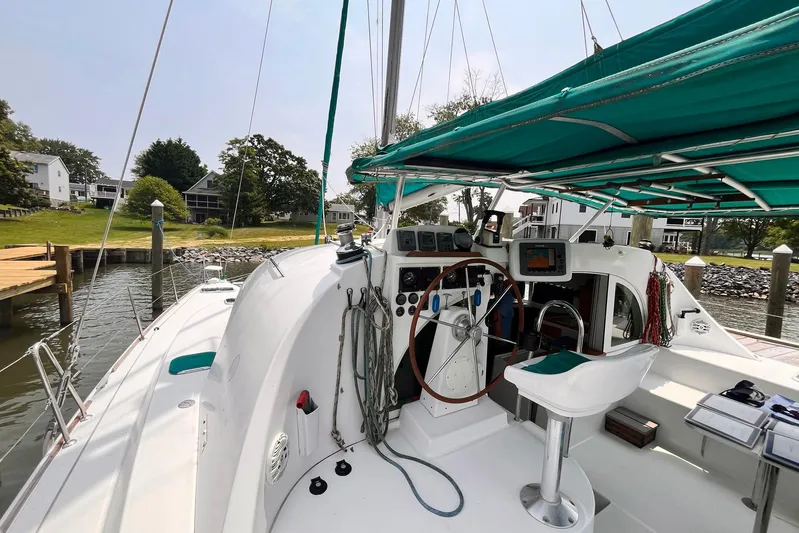 Wayward Sun Yacht Photos Pics Cockpit of a 2000 Lagoon 380 catamaran docked by a scenic waterfront.