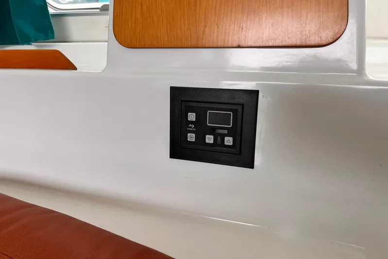 Wayward Sun Yacht Photos Pics Control panel on a 2000 Lagoon 380 yacht interior, featuring wood and white surfaces.
