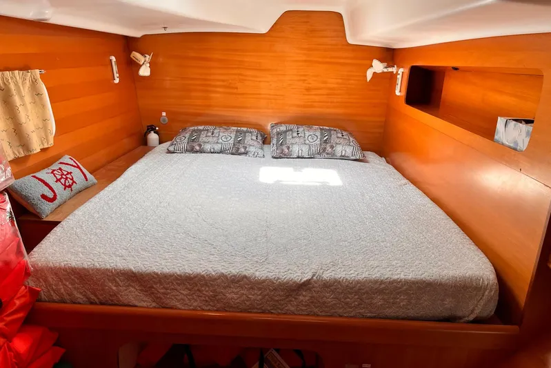 Wayward Sun Yacht Photos Pics Cozy cabin interior of 2000 Lagoon 380 catamaran with double bed and wooden finish.