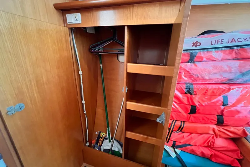 Wayward Sun Yacht Photos Pics Wooden storage cabinet on Lagoon 380 yacht, featuring shelves and life jackets.