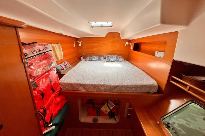 Wayward Sun Yacht Photos Pics Cozy cabin interior of 2000 Lagoon 380 catamaran with bed and life jackets.