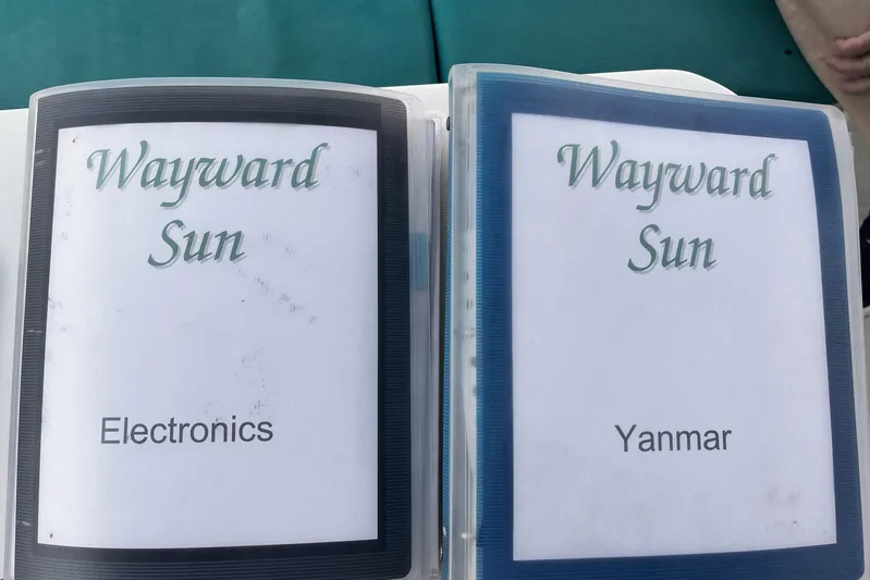 Wayward Sun Yacht Photos Pics Binders labeled "Wayward Sun" for electronics and Yanmar on a Lagoon 380, 2000 model.