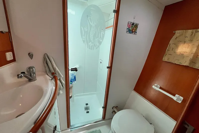 Wayward Sun Yacht Photos Pics Bathroom interior of 2000 Lagoon 380 catamaran with shower, sink, and toilet.