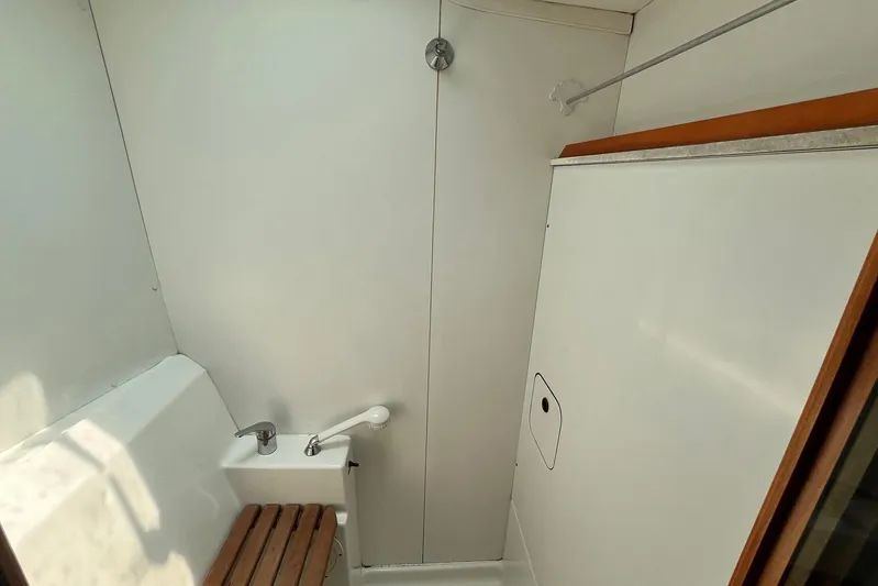 Wayward Sun Yacht Photos Pics Interior of a 2000 Lagoon 380 yacht bathroom with wooden seat and white fixtures.