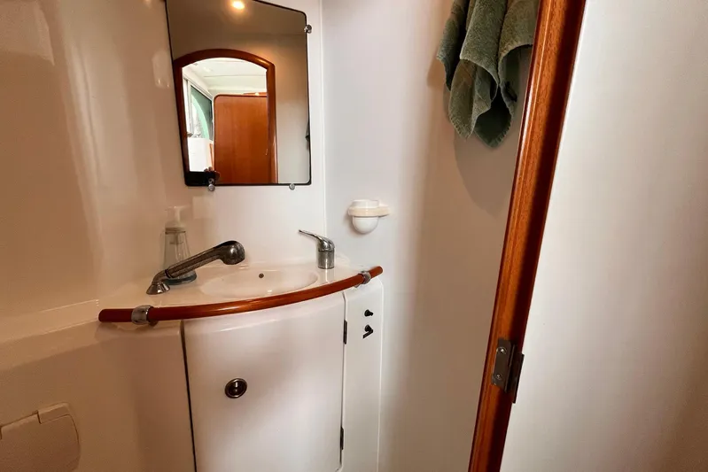 Wayward Sun Yacht Photos Pics Compact bathroom in 2000 Lagoon 380 yacht with sink, mirror, and towel.