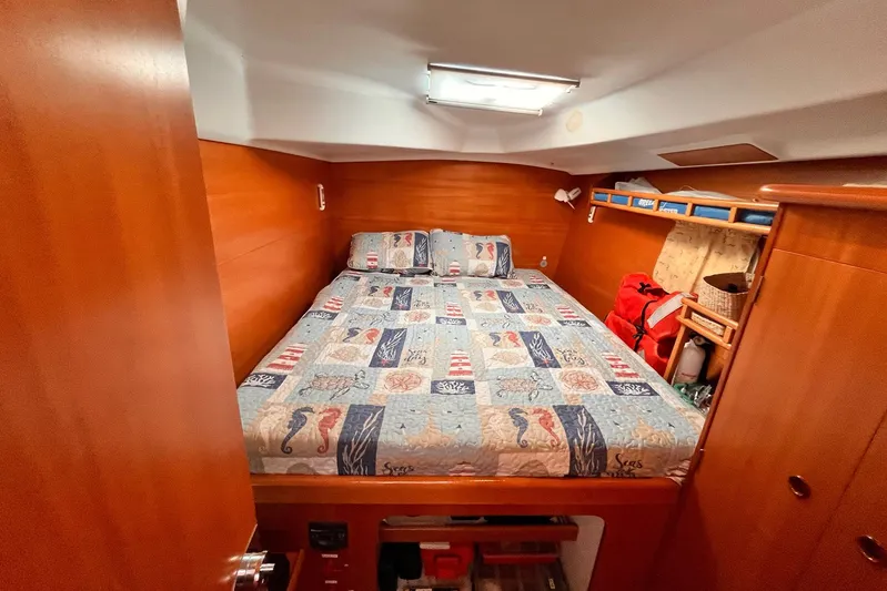 Wayward Sun Yacht Photos Pics Cozy cabin interior of 2000 Lagoon 380 catamaran with nautical-themed bedding.