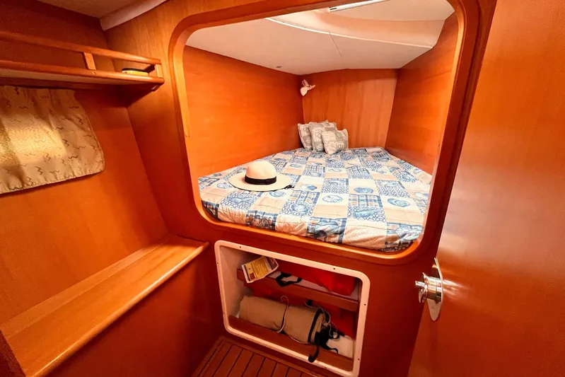 Wayward Sun Yacht Photos Pics Cozy cabin interior of 2000 Lagoon 380 catamaran with bed and storage.