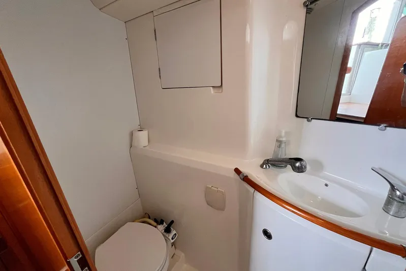 Wayward Sun Yacht Photos Pics Bathroom interior of 2000 Lagoon 380 catamaran with sink, mirror, and toilet.