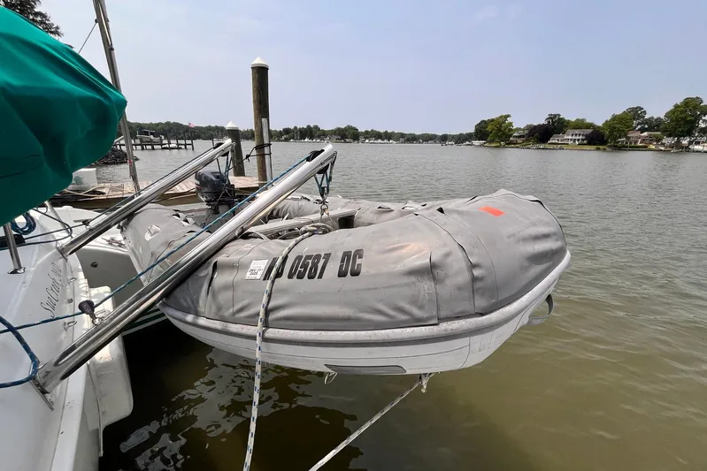 Wayward Sun Yacht Photos Pics Lagoon 380 catamaran with dinghy docked on a serene lake, 2000 model.