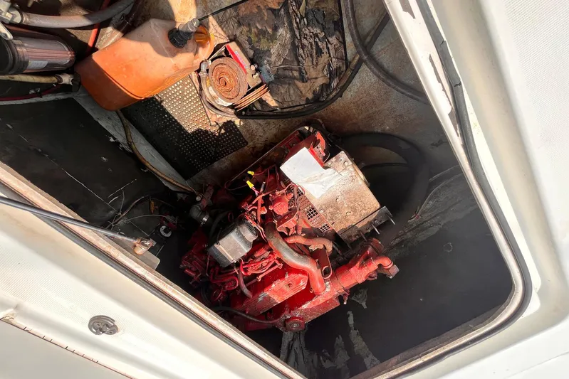 Wayward Sun Yacht Photos Pics Engine compartment of a 2000 Lagoon 380 catamaran, showing a red engine and surrounding components.