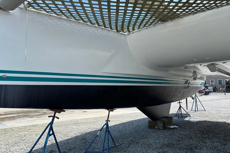 Wayward Sun Yacht Photos Pics Lagoon 380 catamaran from 2000 on stands, showcasing hull and netting.