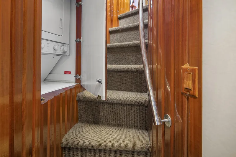Bellissimo Yacht Photos Pics Staircase with carpet and laundry area in 2001 Hatteras 63 Cockpit Motor Yacht.
