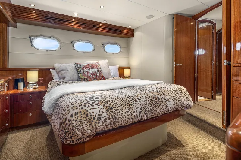 Bellissimo Yacht Photos Pics Luxurious bedroom in 2001 Hatteras 63 Cockpit Motor Yacht with elegant wood finishes.