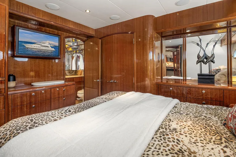 Bellissimo Yacht Photos Pics Luxurious bedroom interior of 2001 Hatteras 63 Cockpit Motor Yacht with elegant wood finishes.