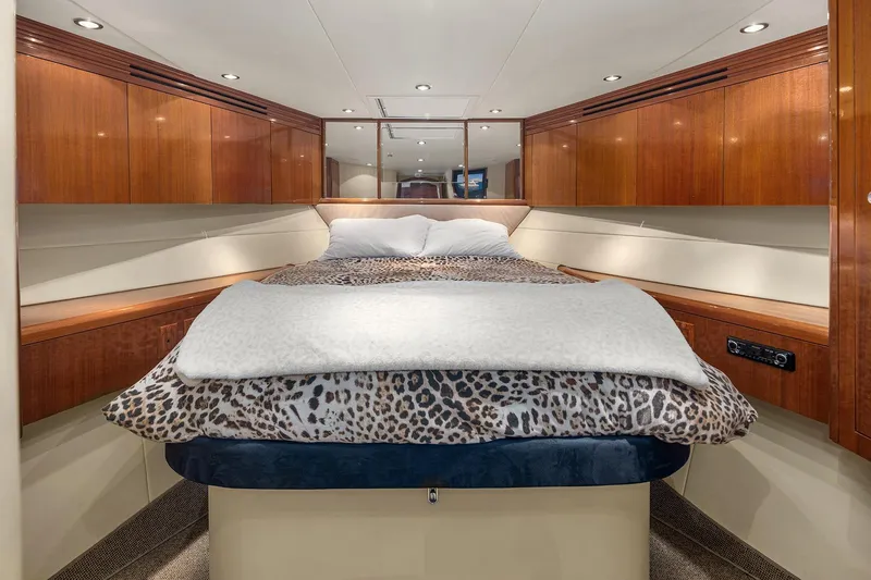 Bellissimo Yacht Photos Pics Luxurious bedroom interior of 2001 Hatteras 63 Cockpit Motor Yacht with elegant wood finishes.