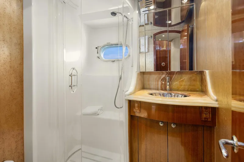 Bellissimo Yacht Photos Pics Luxurious bathroom in 2001 Hatteras 63 Cockpit Motor Yacht with shower and wooden cabinetry.