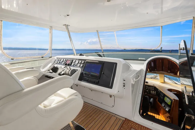 Bellissimo Yacht Photos Pics Helm of 2001 Hatteras 63 Cockpit Motor Yacht with ocean view and modern controls.