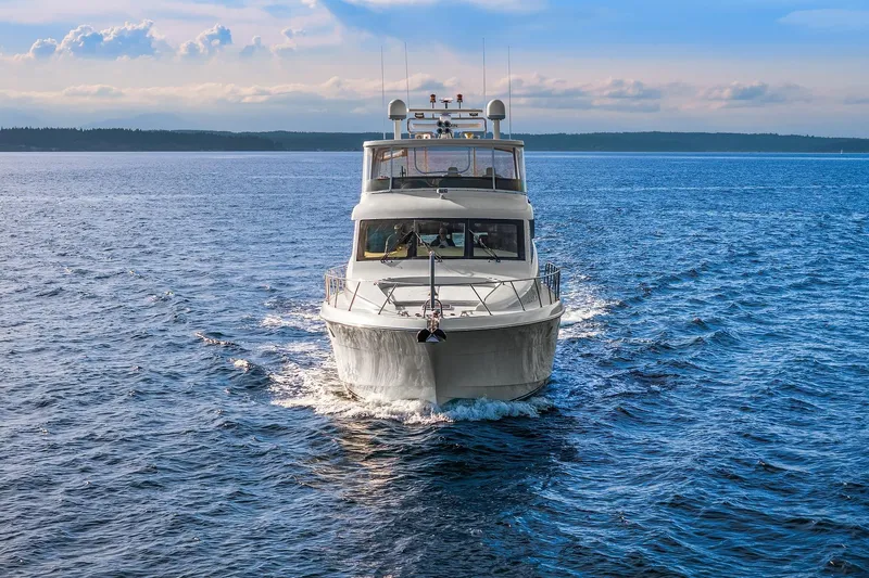Bellissimo Yacht Photos Pics 2001 Hatteras 63 Cockpit Motor Yacht cruising on open water under a blue sky.