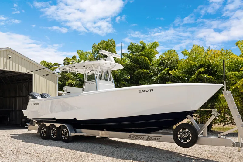  Yacht Photos Pics 2024 Contender 35 ST boat on trailer, parked outdoors near a shed, under a clear blue sky.