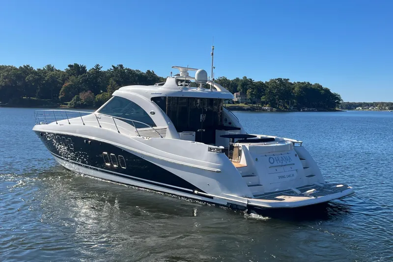 Ohana Yacht Photos Pics 2007 Sea Ray 60 Sundancer yacht cruising on a serene lake under a clear blue sky.