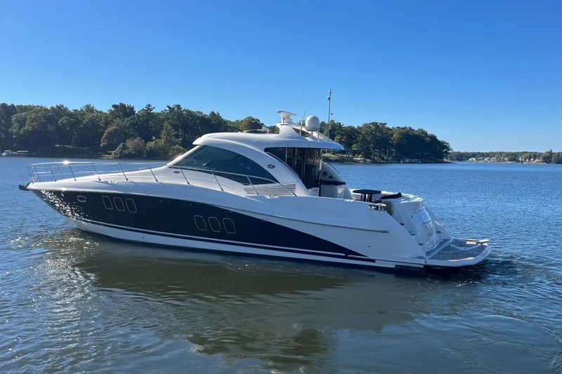 Ohana Yacht Photos Pics 2007 Sea Ray 60 Sundancer yacht cruising on a serene lake under a clear blue sky.