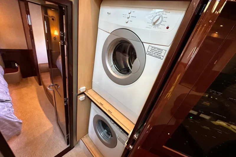 Ohana Yacht Photos Pics Laundry area inside 2007 Sea Ray 60 Sundancer yacht, featuring stacked washer and dryer.
