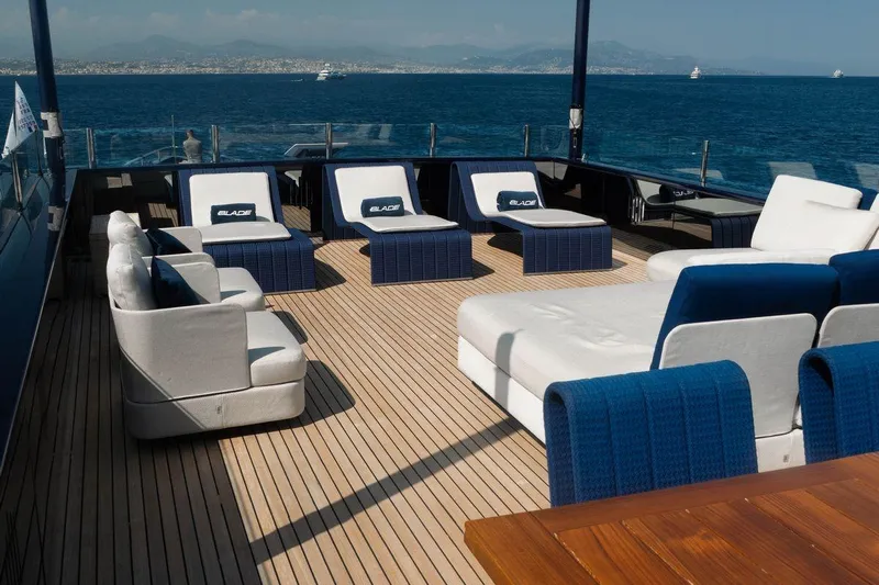 Blade II Yacht Photos Pics Luxurious yacht deck with modern seating, ocean view, and clear skies. MMGI BLADE II, 2009.