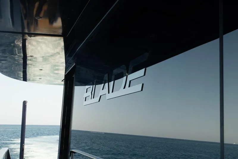 Blade II Yacht Photos Pics Reflective yacht window with "BLADE" logo, ocean view, MMGI BLADE II, 2009 model.
