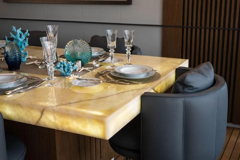 Blade II Yacht Photos Pics Luxurious dining table with elegant glassware and blue coral decor on a marble surface.