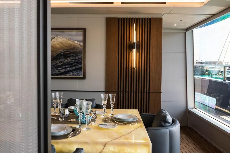 Blade II Yacht Photos Pics Luxurious yacht dining area with elegant table setting, modern decor, and ocean view. MMGI BLADE II 2009.