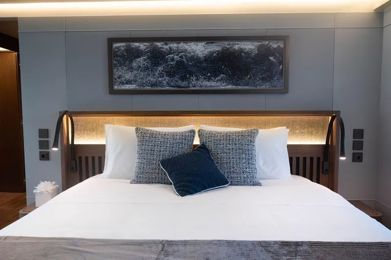 Blade II Yacht Photos Pics Luxurious bedroom interior on MMGI BLADE II yacht, featuring elegant bedding and modern decor.